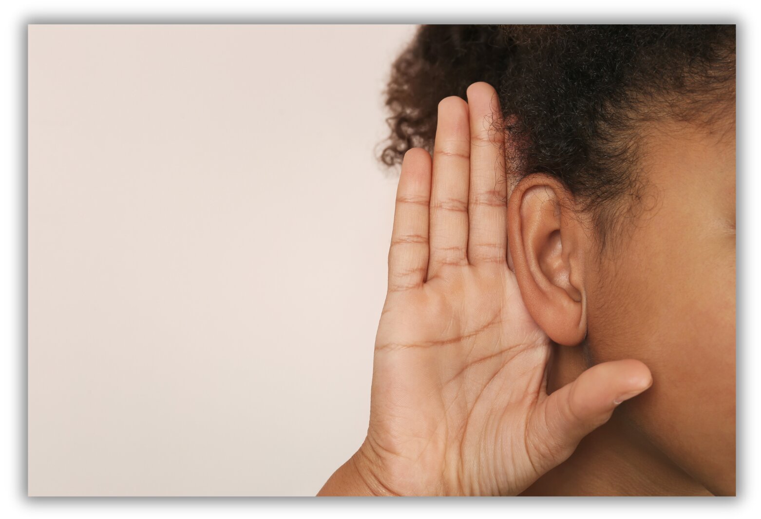 An image of a person holding their hand by their hear to help hear better.